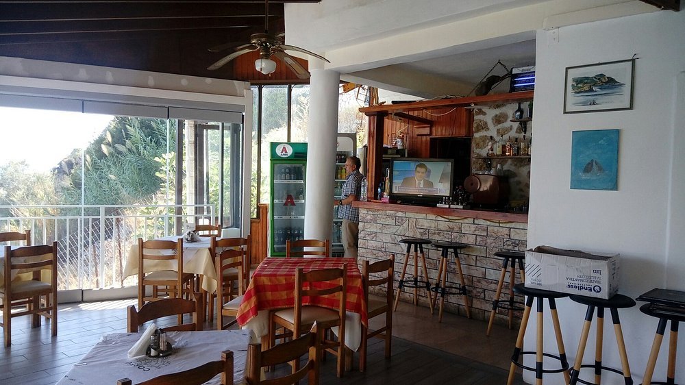 Outdoor dining tables at Dolphin Taverna with relaxed Greek island atmosphere.