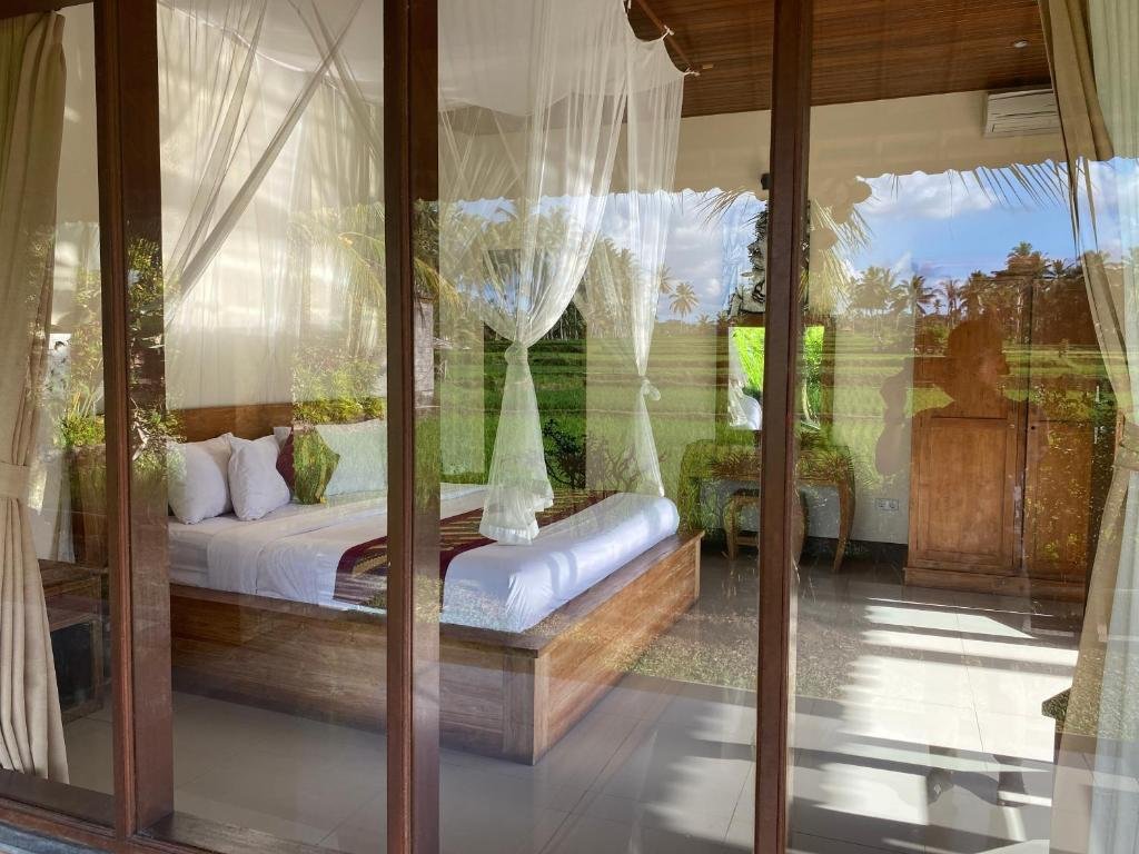 Simple tropical room at Hening Suite Ubud surrounded by greenery