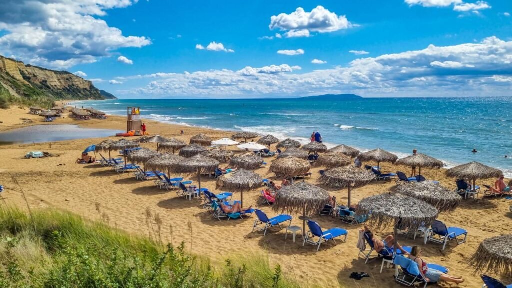 Long sandy Gardenos Beach in Corfu with calm blue water and relaxed atmosphere