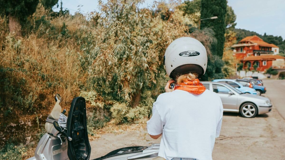 Tourist riding a scooter along a scenic road in Corfu