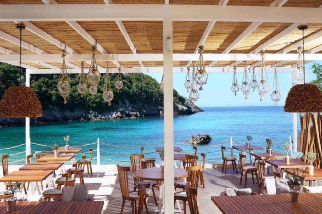 Modern beach bar in Paleokastritsa with stylish lounge seating and turquoise water view.