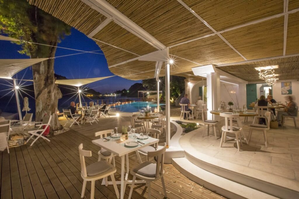 Evening lights at Akron Beach Bar with music and sea reflections.