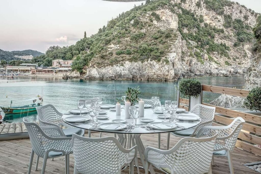 Outdoor terrace of Vrachos Restaurant with tables facing the sea and relaxed Greek island atmosphere.