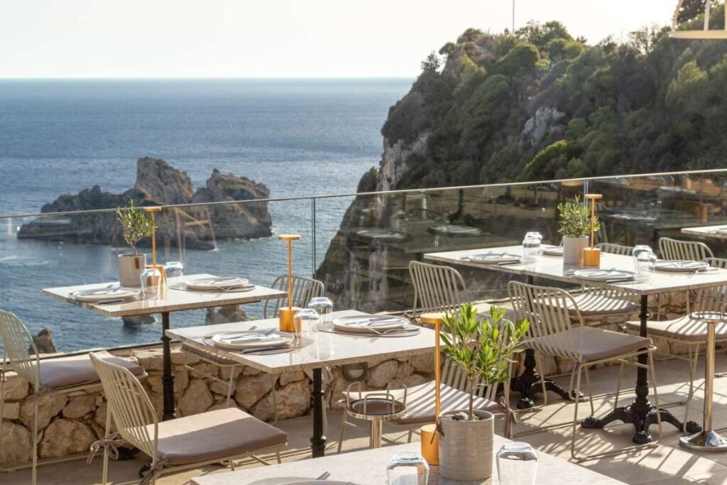 Elegant hillside restaurant above Paleokastritsa monastery with panoramic coastal view.