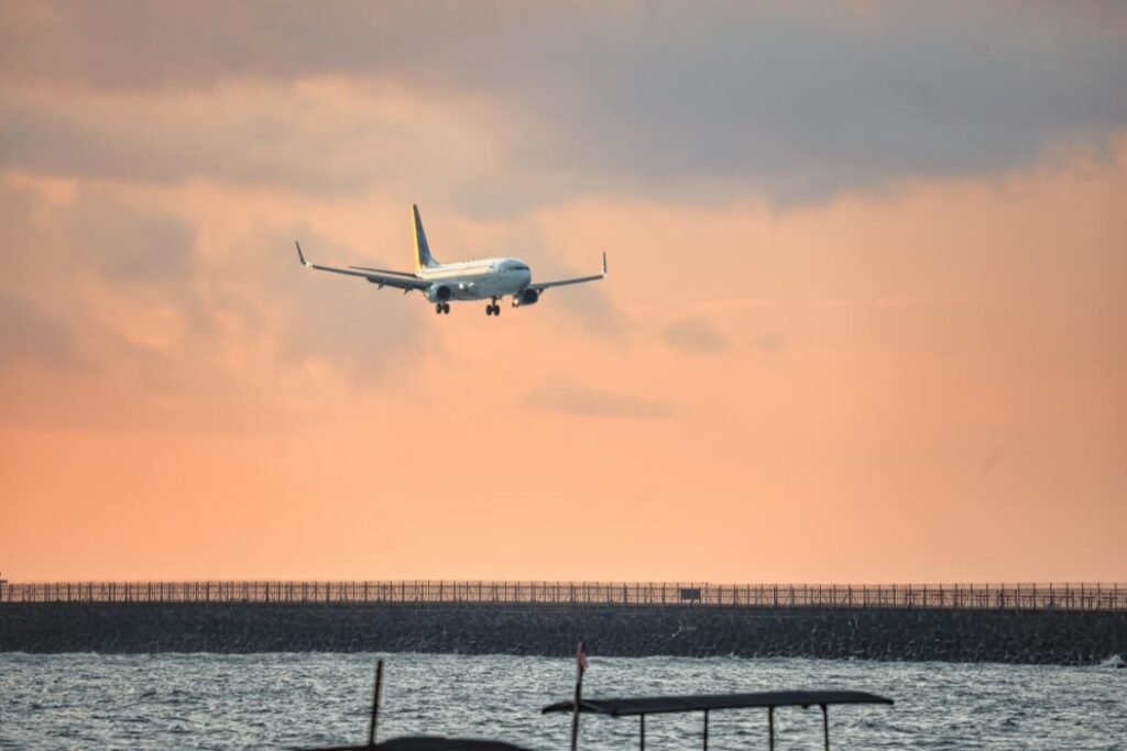 Airplane landing at Bali airport during sunset