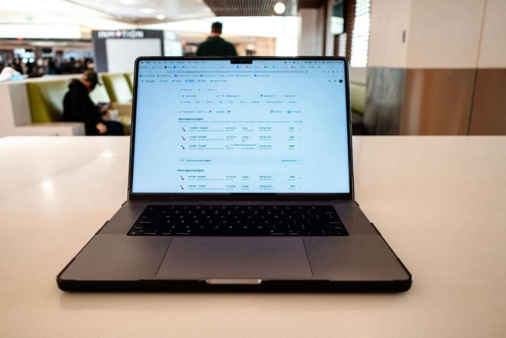 Person searching for cheap flights on a travel booking website using laptop