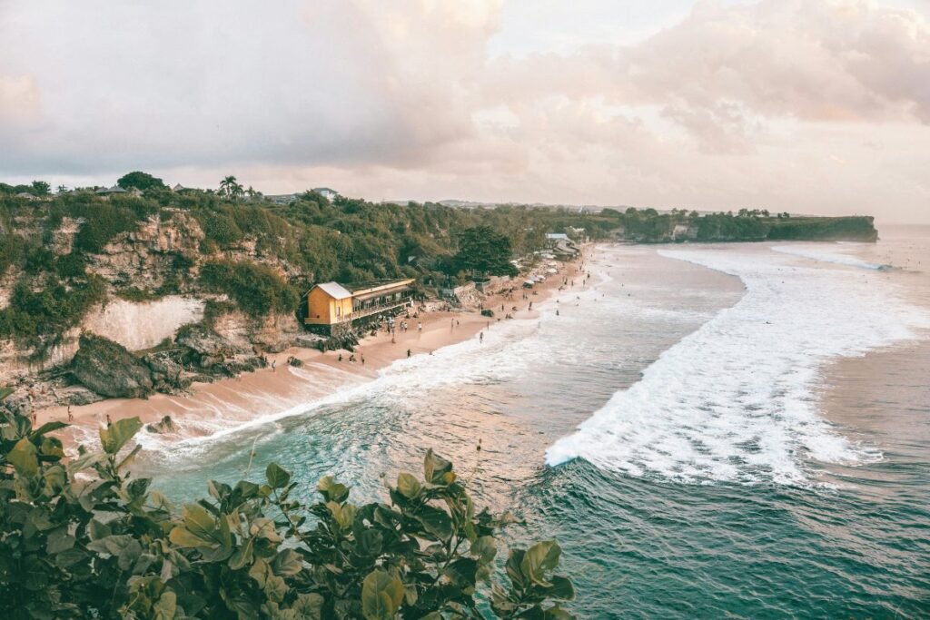 Balangan Beach cliffs and surfers during sunse