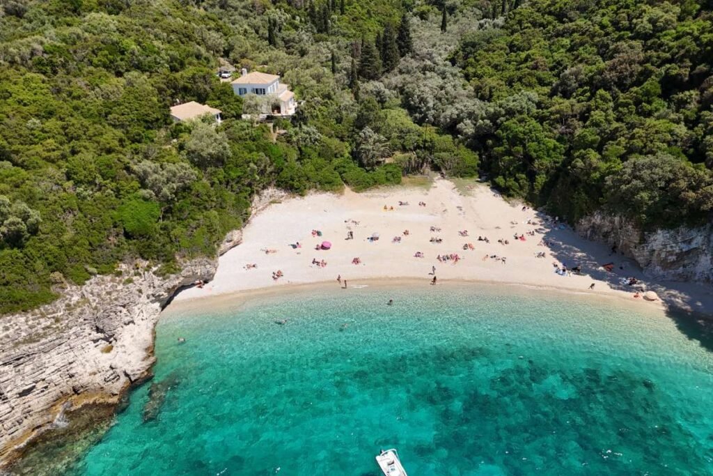 Hidden Rovinia Beach in Corfu surrounded by cliffs and olive trees