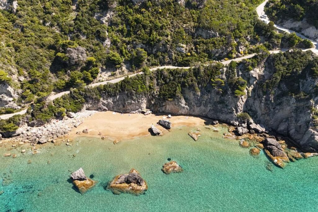 Secluded Mirtiotissa Beach hidden between green cliffs in Corfu Greece