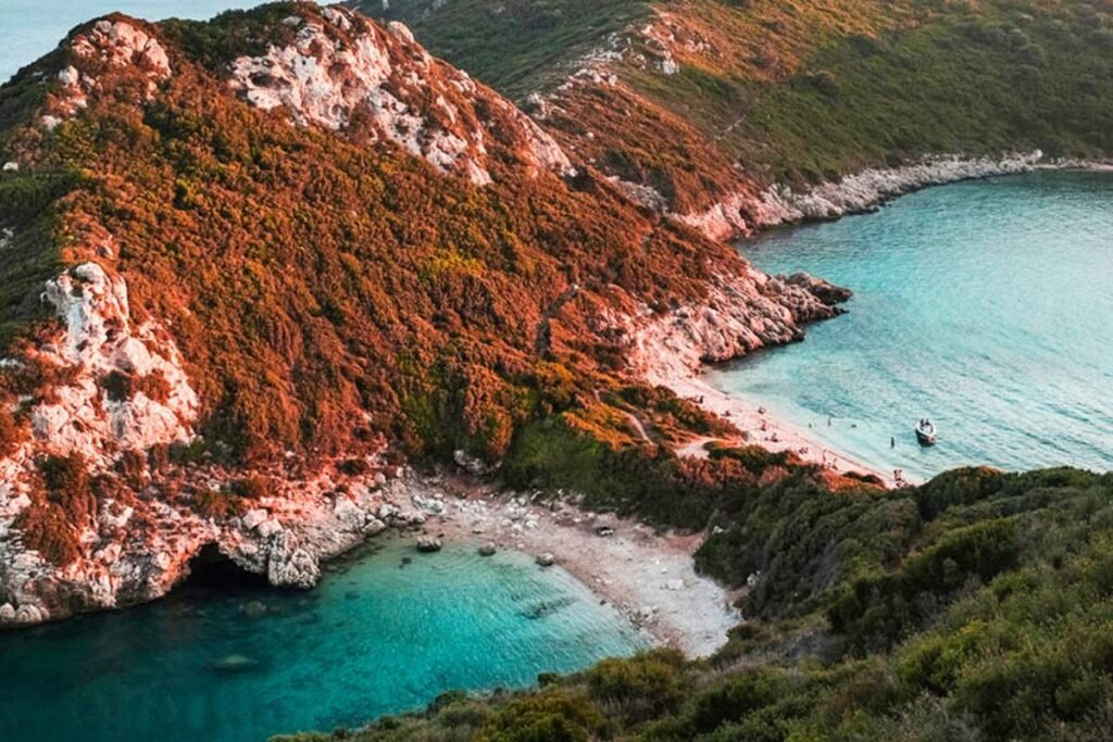 Sunset over Porto Timoni beach with golden sky and calm sea in Corfu