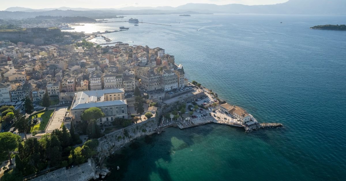 Beautiful panoramic view of Corfu, Greece with turquoise sea, colorful coastal towns, and traditional Mediterranean architecture.
