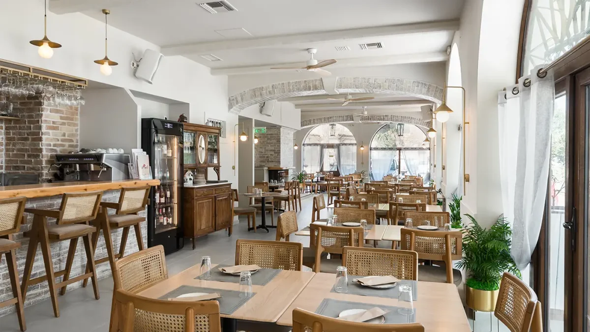 Small intimate restaurant courtyard with rustic tables and traditional Greek food in Corfu Town.