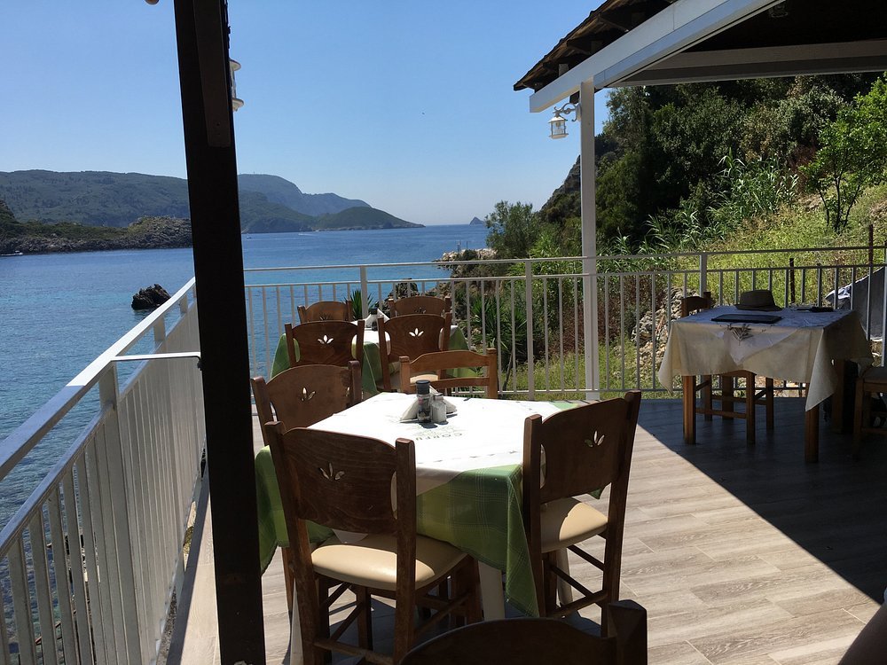 Traditional Greek taverna overlooking Paleokastritsa bay with panoramic sea view.
