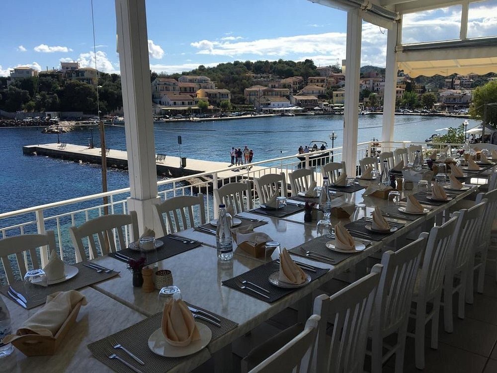 Outdoor terrace at Kima Restaurant in Kassiopi overlooking the harbor and the Ionian Sea.