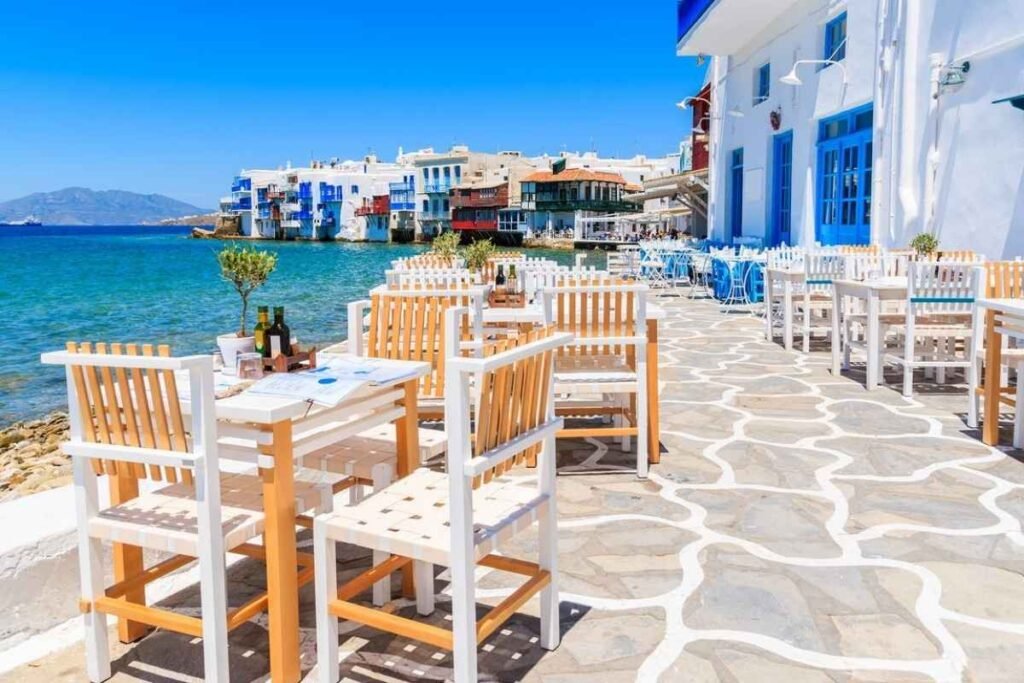 Mykonos Greece white houses and chairs by the sea