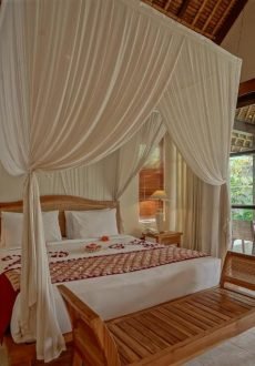 Luxury Balinese suite with handcrafted wooden furniture at Pertiwi Resort Ubud