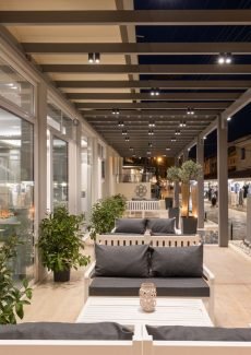 Outdoor terrace at Melina Oasis Boutique Hotel overlooking the street and Kassiopi Harbor