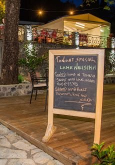 Evening dining at Nausika Taverna with warm lights and sea reflections in Paleokastritsa.