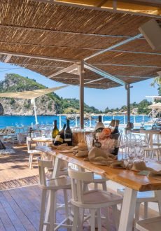 Cocktails served at beach bar in Corfu with sunset and sea background.